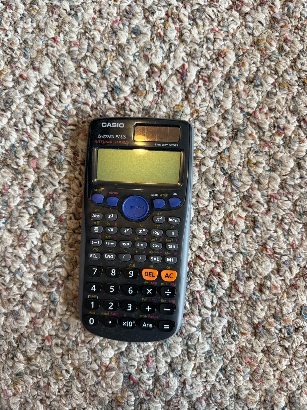 Casio scientific calculator in black with blue and orange keys